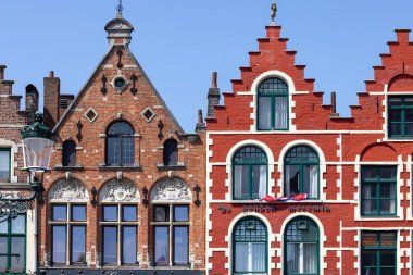 Bruges, Belçika - 19 Mayıs 2023: Pazar Meydanı 'ndaki renkli geleneksel apartman evleri cephesi (Grote Markt)