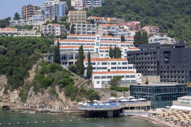 Budva, Karadağ - 28 Haziran 2023: Eski Kasaba Kalesi ve Adriyatik Denizi kıyısından Ricardova Glava Sahili ve modern otellerle manzara