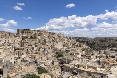 İtalya, Matera - 22 Mayıs 2024: Matera 'nın Sassi kayasına oyulmuş tarihi kentin Piazzetta Pascoli meydanından panoramik manzara. Matera Katedrali 'nin çan kulesi.