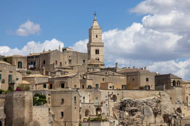 İtalya, Matera - 22 Mayıs 2024: Matera 'nın Sassi kayasına oyulmuş tarihi kentin Piazzetta Pascoli meydanından panoramik manzara. Matera Katedrali 'nin çan kulesi.