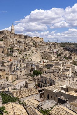 İtalya, Matera - 22 Mayıs 2024: Matera 'nın Sassi kayasına oyulmuş tarihi kentin Piazzetta Pascoli meydanından panoramik manzara. Matera Katedrali 'nin çan kulesi.