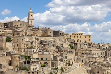 İtalya, Matera - 22 Mayıs 2024: Matera 'nın Sassi kayasına oyulmuş tarihi kentin Piazzetta Pascoli meydanından panoramik manzara. Matera Katedrali 'nin çan kulesi.