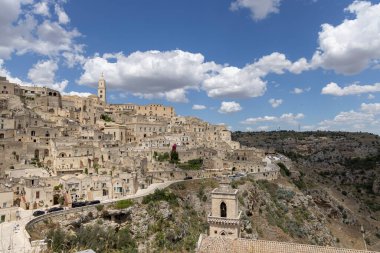 Matera, İtalya - 22 Mayıs 2024: Matera 'nın Sassi kayasına oyulmuş tarihi şehrin panoramik manzarası. Matera Katedrali 'nin çan kulesi.