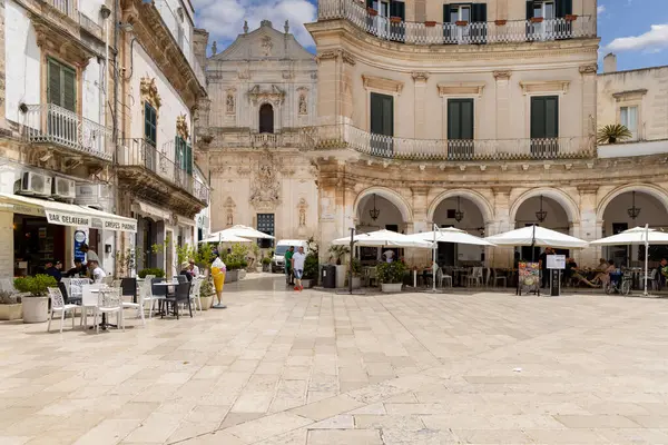 Martina Franca, İtalya, Apulia - 25 Mayıs 2024: Maria Immaculate Meydanı (Piazza Maria Immacolata), neoklasik tarzda tarihsel portici. Uzakta San Martino Bazilikası