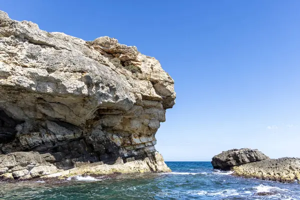 stock image View from the water of picturesque coastline with cliffs and caves by Adriatic Sea, Polignano a Mare, Italy, Apulia. Boat cruise along the rocky coast is a great tourist attraction