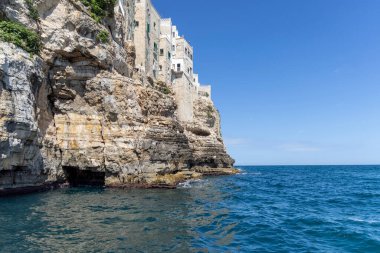 Uçurumlar üzerine inşa edilmiş binalar, resimli kaya ve mağara denizi manzarası, Polignano a Mare, İtalya, Apulia. Kayalık sahil boyunca bir gezi büyük bir turistik cazibedir.