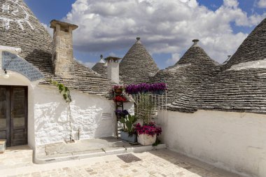 Alberobello, Apulia, İtalya - 21 Mayıs 2024: Trulli evleri, geleneksel, eşsiz, konik çatısı olan Apulian kuru taş barakası. Trulli, UNESCO Dünya Mirasları Listesine dahil edildi