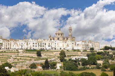 Locorotondo, İtalya, Apulia - 20 Mayıs 2024: Itria Vadisi 'nden şehrin panoramik, pitoresk manzarası. Mavi gökyüzünün arka planında beyaz binalar