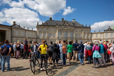 Kopenhag, Danimarka - 22 Haziran 2019: Amalienborg sarayının önündeki avluda nöbet değişimini bekleyen turistler
