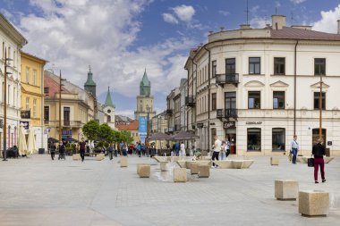 Lublin, Polonya - 24 Mayıs 2022: Krakowskie Przedmiescie Caddesi 'ndeki Mieczyslaw Albert Krapec Meydanı' ndan bir sürü insan sokakta yürüyor. Trinitarian Kulesi ve Belediye Binası