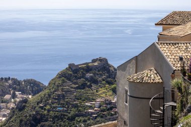 Castelmola, Sicilya, İtalya - 28 Nisan 2023: Akdeniz kıyısındaki San Giorgio Kilisesi ve Taormina Kalesi 'nin Aziz Anthony Meydanı' ndan (Piazza Saint Antonio) görüş