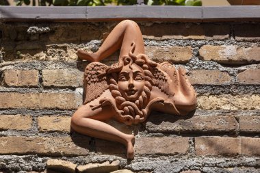 Taormina, Sicilya, İtalya - 28 Nisan 2023: Geleneksel el yapımı seramik Triskelion (Trinacria) ile bina duvarı, üç ayaklı Medusahead figürü, Sicilya 'nın resmi sembolü