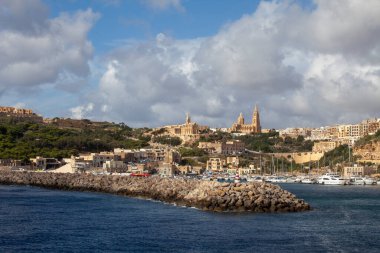 Malta, Gozo Adası, Mgarr - 22 Ekim 2015: Tepedeki liman ve şehir denizi manzaralı. Şehrin üzerinde yükselen iki gotik kilise.