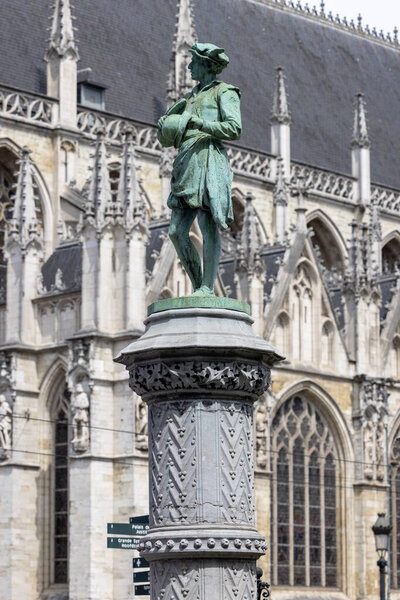 Брюссель, Бельгия - 18 мая 2023 года: Одна из 48 статуй, воплощающих различные гильдии Брюсселя в саду ренессанса площади Пети Саблон. Церковь Пресвятой Богородицы в Саблоне на заднем плане