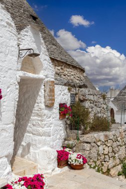 Alberobello, Apulia, İtalya - 21 Mayıs 2024: Trulli evleri, geleneksel, eşsiz, konik çatısı olan Apulian kuru taş barakası. Trulli, UNESCO Dünya Mirasları Listesine dahil edildi