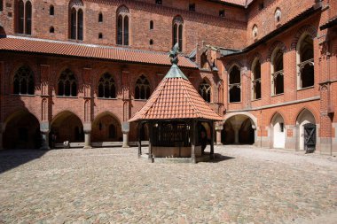 Malbork, Polonya - 25 Haziran 2020: 13. yüzyıl Malbork Kalesi ile avlu, Nogat Nehri 'ndeki ortaçağ Töton kalesi. UNESCO Dünya Mirası Bölgesi, dünyanın en büyük şatosudur.