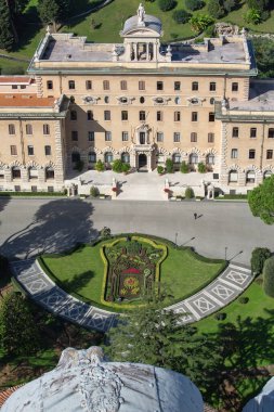 Vatican; Rome; Italy - October 9; 2020: Aerial view from dome of Saint Peter's Basilica of Vatican Gardens with Papal coat of arms made of flowers in front of Governor's Palace clipart