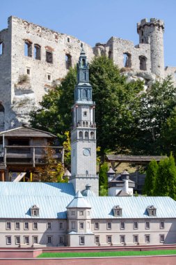 Ogrodzieniec, Podzamcze, Poland - August 31, 2017: 1:25 scale miniature of 14th century medieval Jasna Gora Monastery, Ogrodzieniec Miniature Park. Ruins of Ogrodzieniec Castle in a background clipart