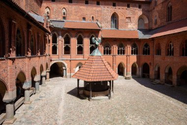 Malbork, Polonya - 25 Haziran 2020: 13. yüzyıl Malbork Kalesi ile avlu, Nogat Nehri 'ndeki ortaçağ Töton kalesi. UNESCO Dünya Mirası Bölgesi, dünyanın en büyük şatosudur.