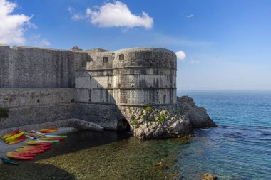 Dubrovnik, Hırvatistan - 27 Haziran 2023: Eski Duvarlar ve Bokar Kulesi 'ndeki Adriyatik Denizi kıyısındaki Kolorina Sahili' nde renkli kayıklar için marina manzarası