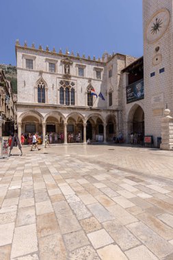 Dubrovnik, Hırvatistan - 27 Haziran 2023: Gotik-rönesans ortaçağ Sponza Sarayı da, Saat Kulesi 'nin yanındaki Luza Meydanı' nda bulunan Divona 'da yer alıyor.