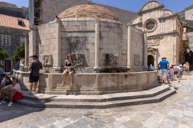 Dubrovnik, Croatia - June 27, 2023: Great Well of Onofria, fountain near the Pilska Gate, built as part of the water supply system. Water flows from stone gargoyles. clipart