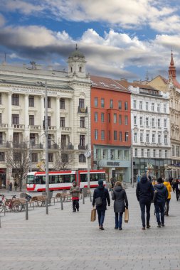 Brno, Çek Cumhuriyeti - 5 Mart 2023: Renkli apartman evleri, yürüyen insanlar ve kırmızı tramvayla şehir merkezinde Özgürlük Meydanı