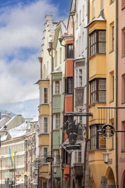 Innsbruck, Tyrol, Avusturya - 26 Şubat 2023: Herzog-Friedrich caddesindeki tarihi konutların renkli cephelerinin görüntüsü