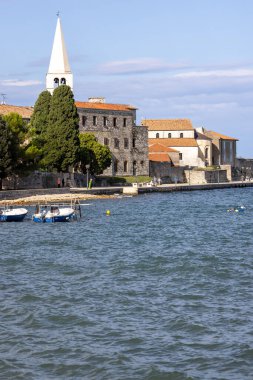 Porec, Croatia, Istria - September 25, 2023: View from  Nikole Tesle street of seaside with bell tower of Byzantine architecture Euphrasian Basilica clipart