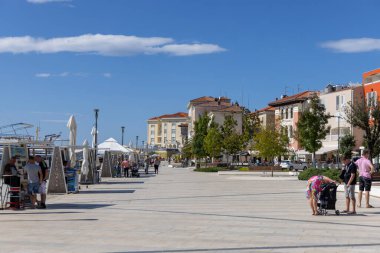 Porec, Hırvatistan, Istria - 25 Eylül 2023: Mareşal Tito Caddesi 'nde liman, gemiler ve yolcu feribotları için liman. Deniz kenarında güzel bir gezinti alanı.