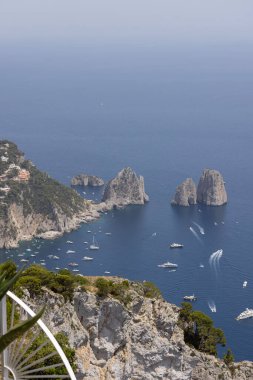 Faraglioni, İtalya 'nın Capri adasının dışındaki Napoli Körfezi' ndeki üç küçük kayalık adanın Monte Solaro 'dan havadan görüntüsü. Dalgaların aşındırdığı ünlü bir kıyı kayası oluşumu. Tyrhenian Denizi 'nin resimli kayalık kıyıları
