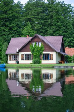 Masuria, Masurian Gölü Toprakları, Nidzkie Gölü, Polonya - 24 Haziran 2020: Büyüleyici bir göl evi, suda ayna yansıması