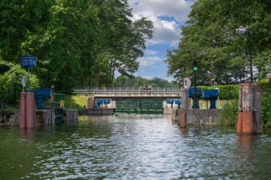 Masuria, Masurian Lake Land; Poland - June 24, 2020: Lake in Polish Masuria with canal lock Guzianka, ship route between two lakes clipart