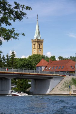Mikolajki, Masurian Gölü Toprakları, Masuria, Polonya - 24 Haziran 2020 Talty Gölü üzerindeki köprü ve Kutsal Üçleme Kilisesi Kulesi