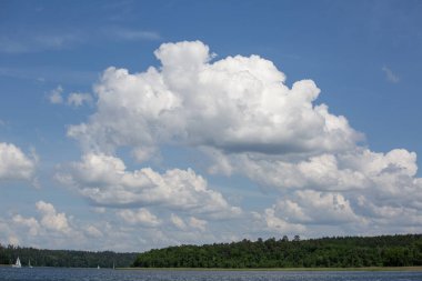 Lake in Polish Masuria with sailing yachts on sunny day. Picturesque cloudy sky, beauty of nature, Masurian Lake Land, Poland clipart