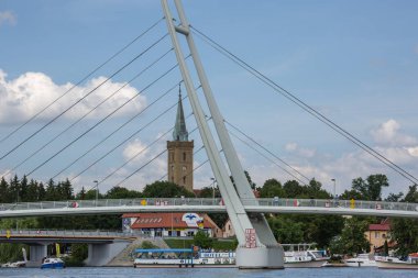 Mikolajki, Masurian Lake Land, Polonya - 24 Haziran 2020: Asma köprünün Mikolajskie Gölü manzarası, yat ve tekneler için yat limanı. Kutsal Üçlü Kilisesi