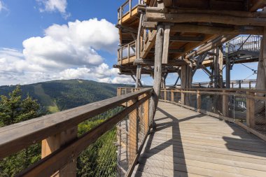 Ağaç tepelerinde bulunan Slotwiny Arena kayak istasyonunun tepesinde bulunan ahşap gözlem kulesi, güzel dağ zirveleri manzarası, Krynica Zdroj, Beskid Dağları, Slotwiny, Polonya 