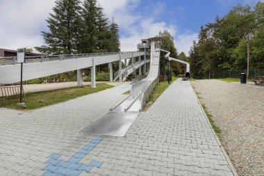 Krynica-Zdroj, Polonya - 31 Ağustos 2022: Jaworzyna Sıradağları 'ndaki Gora Parkowa' nın tepesindeki eski kızak koşusunun ve cennet kaymalarının başlangıç kulesi. Şehrin en önemli eğlence alanlarından biridir.