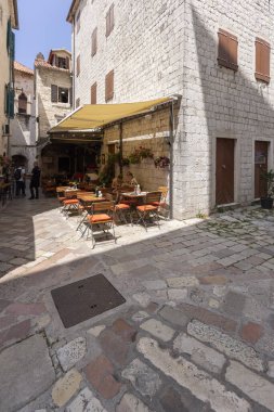 Kotor, Karadağ - 26 Haziran 2023: Eski Şehir 'de taş konutlarla çevrili, dış restoranları olan küçük bir kare