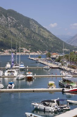 Kotor, Karadağ - 26 Haziran 2023: Kotor Limanı (Marina Kotor) demirli teknelerle. Adriyatik Denizi kıyısında yer alır ve yüksek dağlarla çevrilidir.