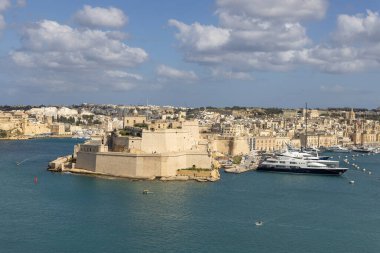 Valletta, Malta - 17 Nisan 2025: St. Angelo Kalesi 'nin Yukarı Barrakka Bahçeleri, kaleli ortaçağ kalesi. Limana demirlemiş lüks yatlar.