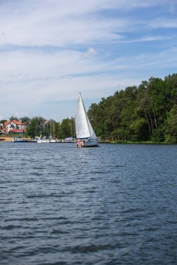 Masuria, Masurian Gölü Toprakları, Polonya - 24 Haziran 2020: Güneşli bir günde denize açılan yatın Masurian Gölleri 'ndeki tipik yat marinasına manzarası
