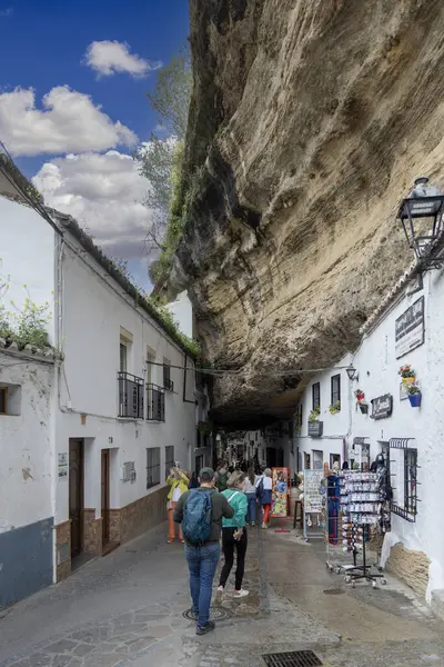 Setenil de las Bodegas, İspanya, Endülüs - 2 Nisan 2025: Uçurumun üzerindeki eşsiz beyaz köy kayalara inşa edildi. Cuevas de la Sombra Caddesi 'ndeki dar dükkan ve restoranlar.