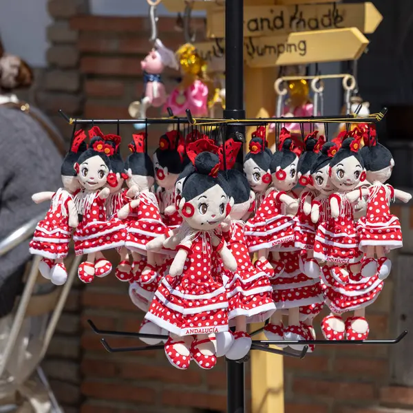 Setenil de las Bodegas, İspanya - 2 Nisan 2025: Renkli flamenko bebekleri sergilenen sokak hediyelik eşya dükkanı, Endülüs 'te geleneksel İspanyol el sanatları ve kültürel hediyeler. Bebeklerin kırmızı elbiseleri vardır.