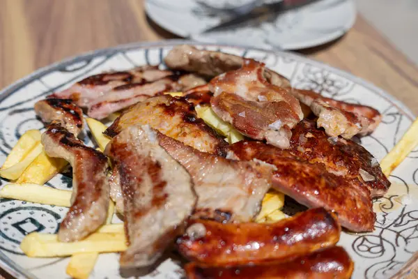 İspanya, Endülüs 'ten geleneksel İspanyol barbekü tabağında domuz pirzolası, sosis ve sucukla karışık İber parrillada.