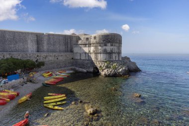 Dubrovnik, Hırvatistan - 27 Haziran 2023: Eski Duvarlar ve Bokar Kulesi 'ndeki Adriyatik Denizi kıyısındaki Kolorina Sahili' nde renkli kayıklar için marina manzarası