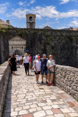 Kotor, Karadağ - 26 Haziran 2023: Ortaçağ nehir kapısı (Kuzey Kapısı) önündeki Scurda nehri üzerindeki taş köprüde turistler)