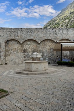 Kotor, Karadağ - 26 Haziran 2023: Taş dekoratif Su Fıskiyeli Eski Şehir Duvarları Tahta Meydanı manzarası