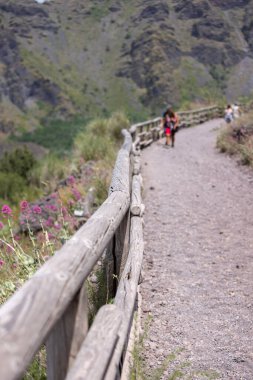 Mount Vesuvius, Naples, Italy - July 29, 2021: Tourists walking along the footpath to the top of Vesuvius volcano on a hot day. The path is made of sharp volcanic tuff