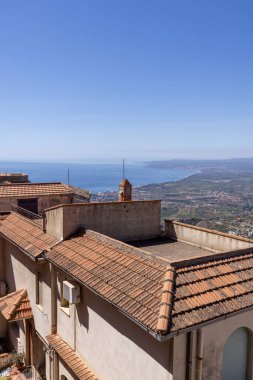 Castelmola, Sicilya, İtalya - 28 Nisan 2023: Mola Şatosu 'ndan İyon Denizi Körfezi' nin havadan görünüşü. Evlerin seramik çatı kiremitleri